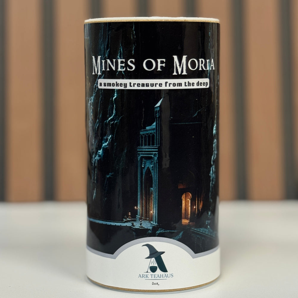 Cylindrical product packaging with 'Mines of Moria' text and dark-themed design on a neutral background