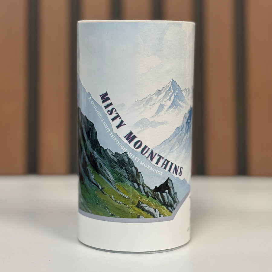 A can of tea called Misty Mountains with pictures of misty mountains on a steep incline